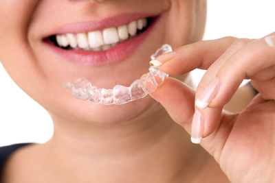 woman is holding Invisalign® braces