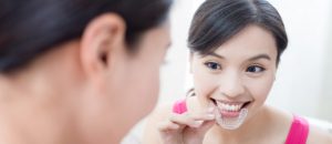 woman putting in invisalign tray