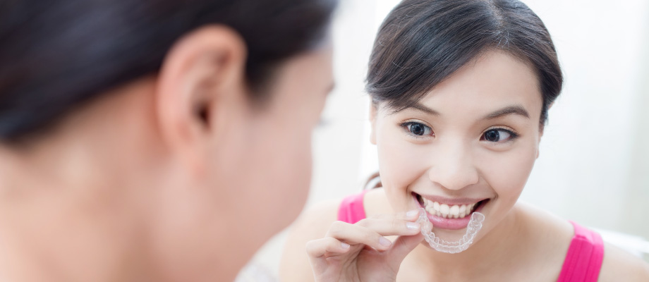 woman putting in invisalign tray