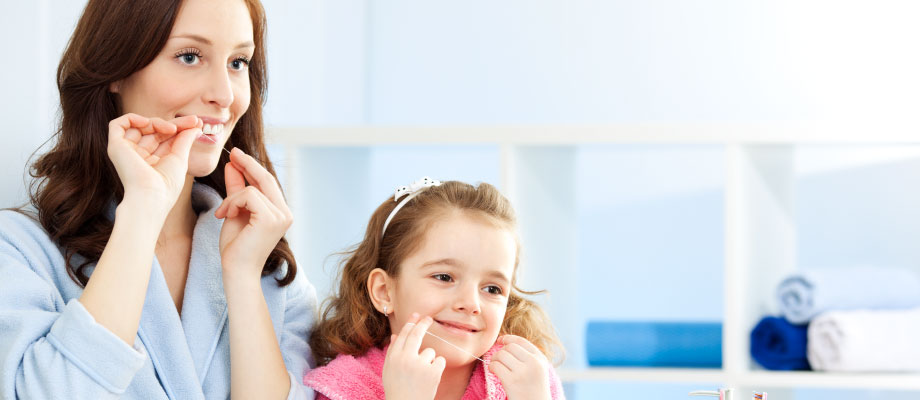 mother and daughter flossing together